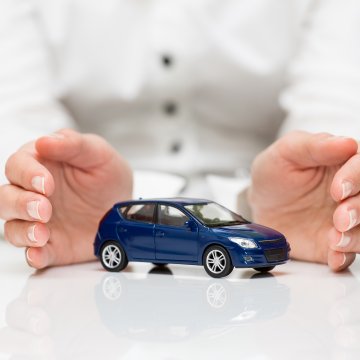 USAA extended car warranty service overview man in white holding blue toy car between hands white background